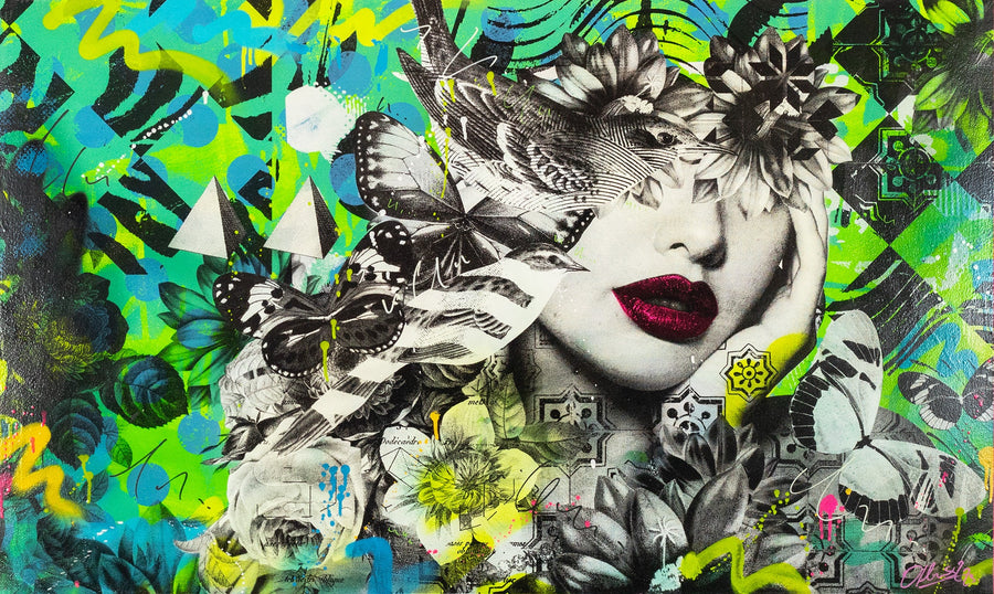 Artist Olly Howe seated in front of his vibrant, layered floral and graffiti-inspired artwork, wearing a black hoodie and cap in a colourful studio setting