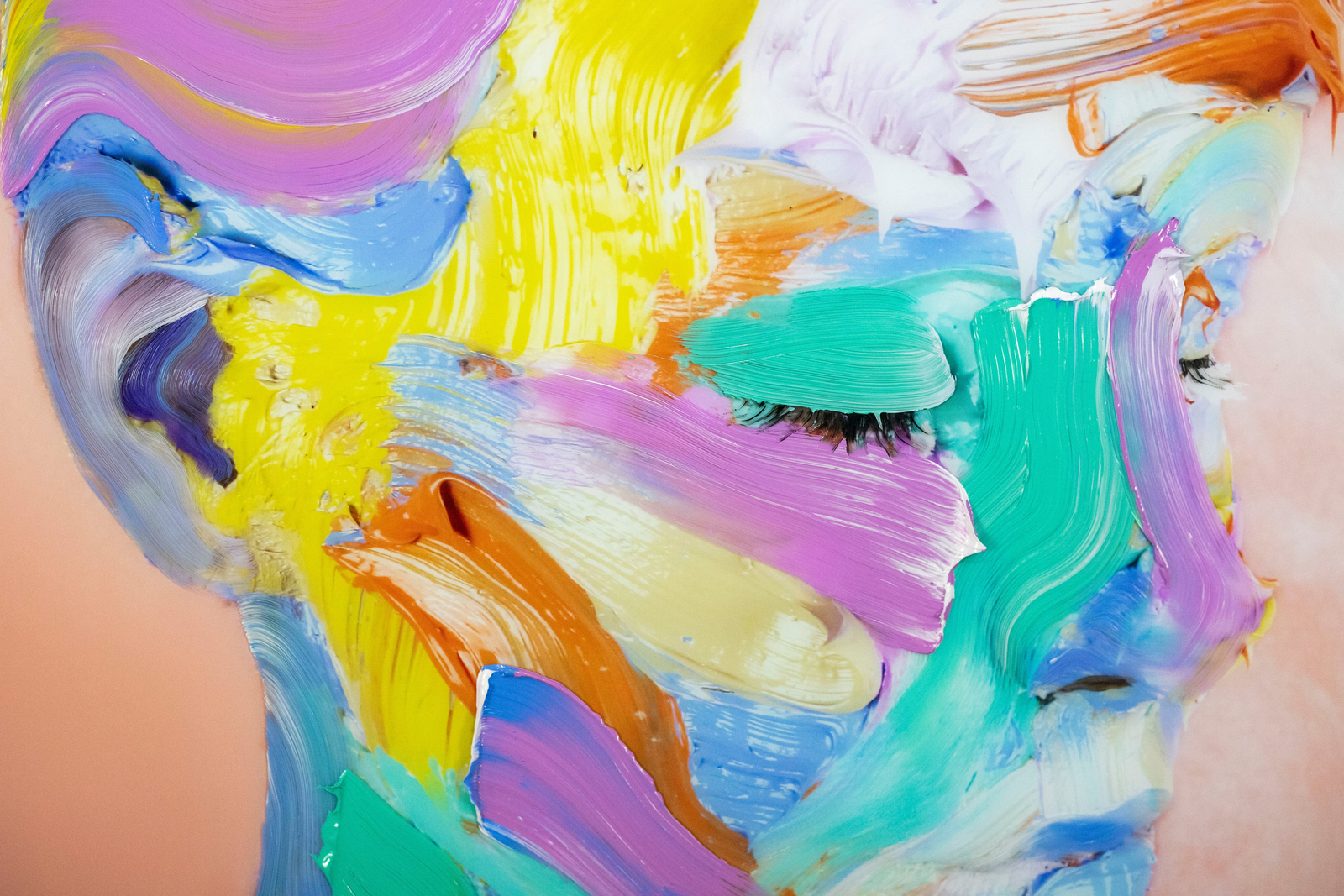 Artist Sophie Derrick painting a vibrant abstract self-portrait in her studio, surrounded by colourful, expressive works on canvas.